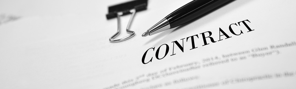 Contract on desk with black pen waiting to be signed